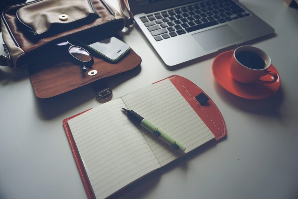 Flat-lay of headphones, coffee, and blank notepad—tools for focus.